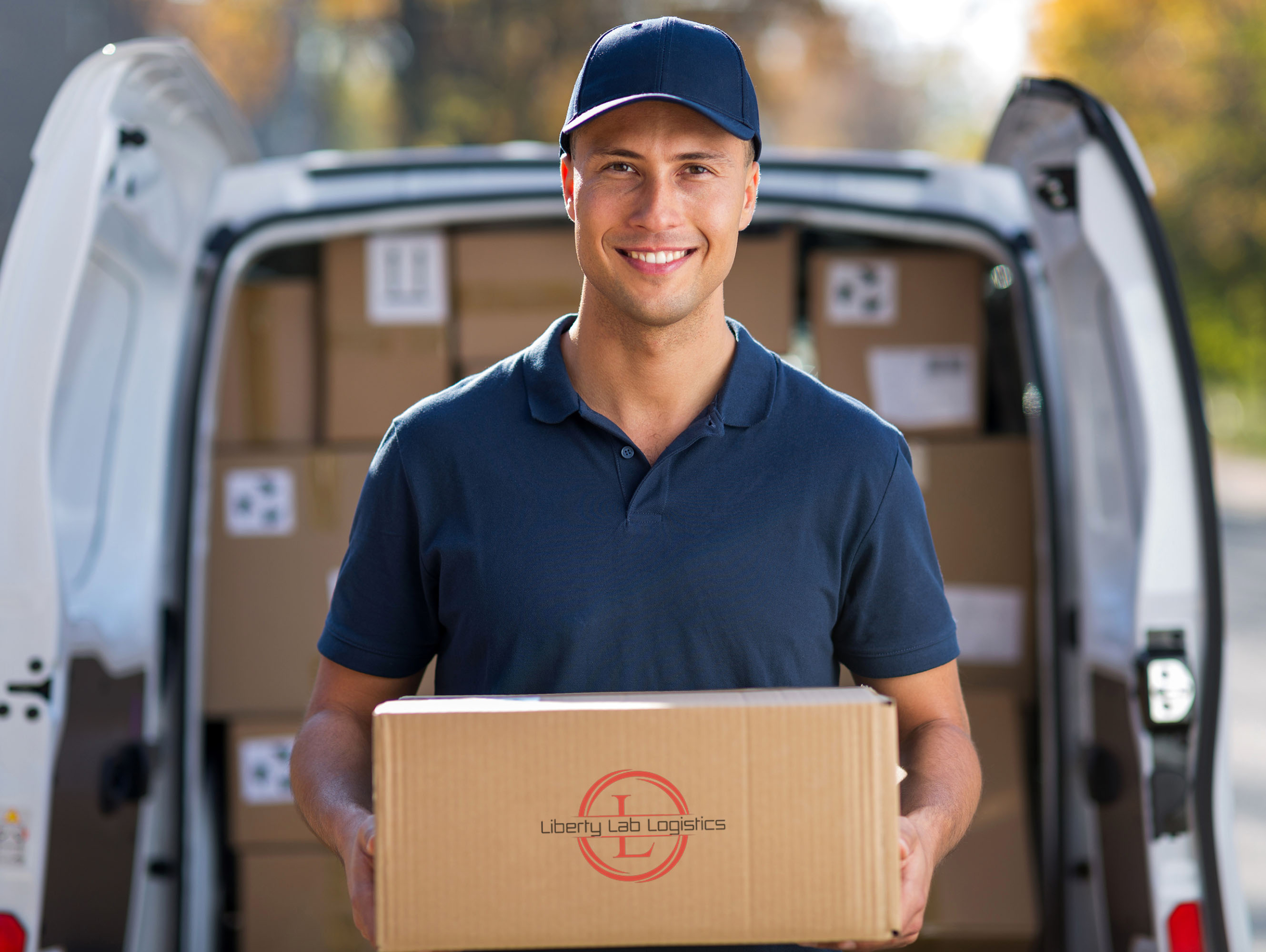 Smiling,Delivery,Man,Standing,In,Front,Of,His,Van